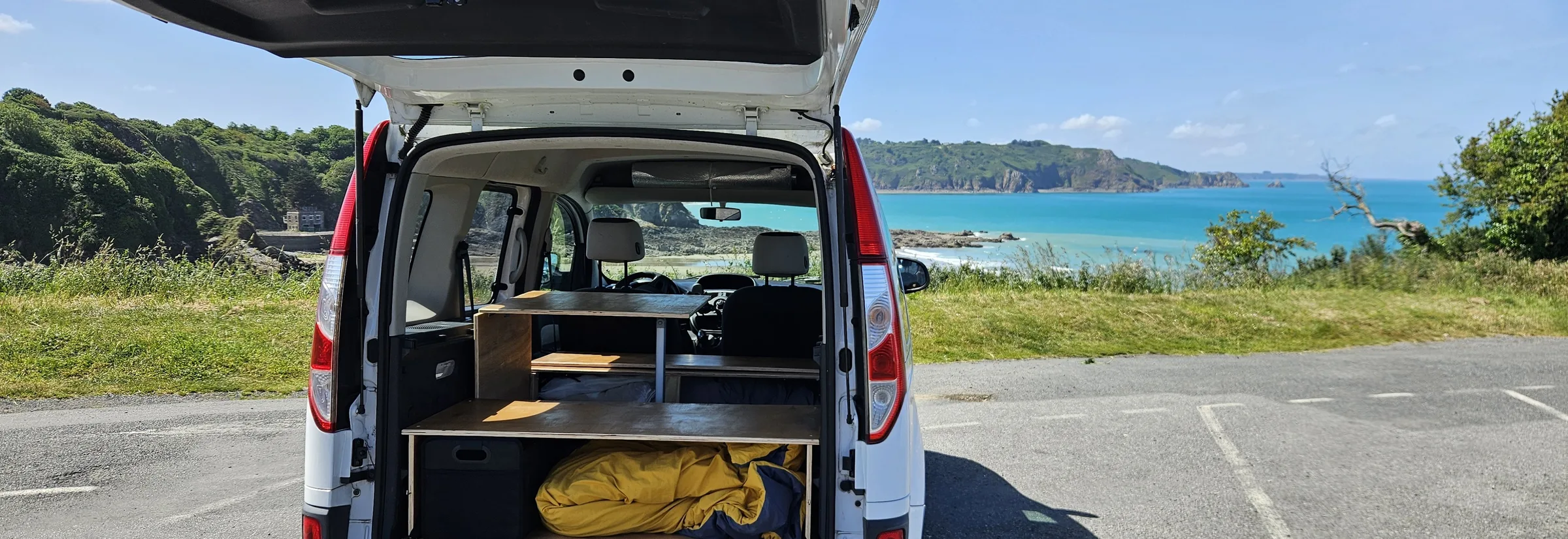 Kangoo aménagé par le MiniVan Kit, coffre ouvert face à la mer