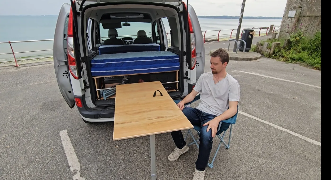 Table du MiniVan Kit installée dehors, vue sur la mer